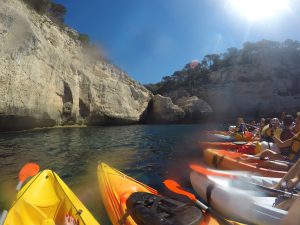 Kayak line up with the caves in the background in Menorca