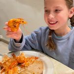 Girl holding cook prawn at Sol Lanzarote restaurant.